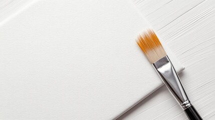 A pristine white canvas with a brush resting on it symbolizing a blank slate or fresh start
