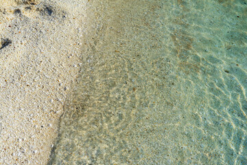 a wave rolls onto a sandy beach