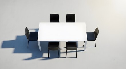 Fototapeta premium Contemporary arrangement of a white table surrounded by sleek black chairs, casting long shadows on a minimalist gray background.