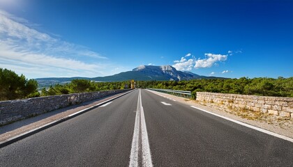 Fototapeta premium narrow highway leading to the mont ventoux in france with a blue sky in the background