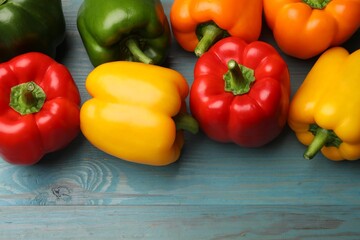 Fresh colorful bell peppers on blue wooden table, flat lay