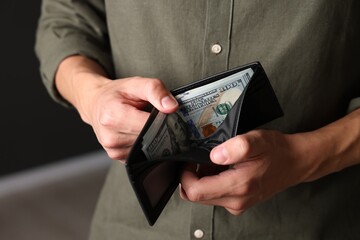 Man with money in wallet indoors, closeup