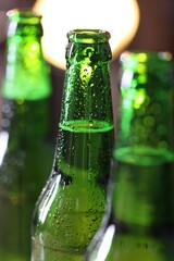 Bottles of beer on blurred background, macro view