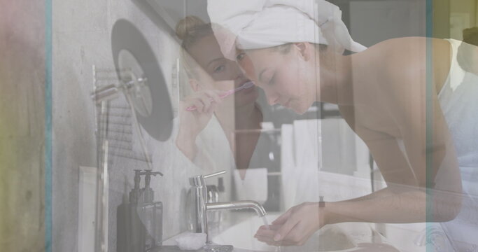 Washing woman leaning over sink faucet while friend brushing teeth with toothbrush in home bathroom - Powered by Adobe
