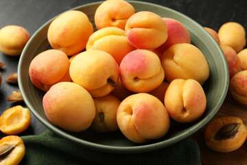 Fresh ripe apricots in bowl on table, closeup