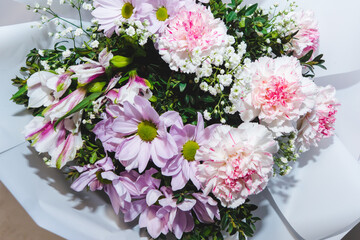 A luxurious bouquet of carnations, daisies, and gypsophila. Bunch of many colorful flowers. Floristry and floral design concept. Floral texture