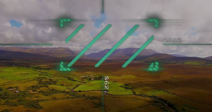 Displaying green heads-up display overlay with corner markers over rural valley with numeric data