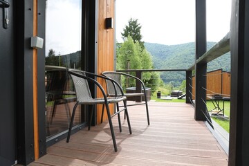Rattan chairs on outdoor terrace at luxury resort in mountains