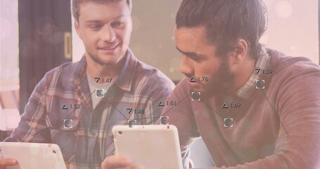 Collaborating men wearing plaid shirt and burgundy sweater using tablets at cafe on wooden table