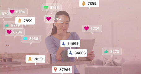 Korean woman holding tablet and contemplating at kitchen peninsula, with mug and notification icons