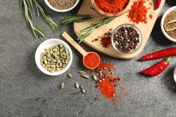 Different aromatic spices on grey table, flat lay