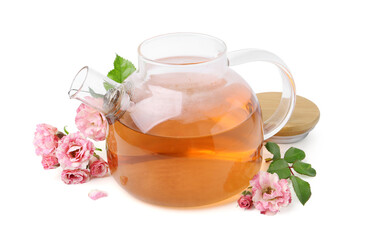 Tasty rose tea in glass teapot, flowers and leaves isolated on white