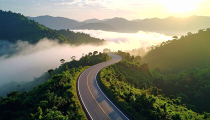 Aerial view of countryside road passing through the green forest and mountain in Thailand.