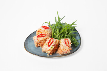 Steamed chicken rolls with vegetables, served with arugula and red pepper on a plate on a white background