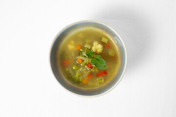 Vegetable soup in a bowl on a white background