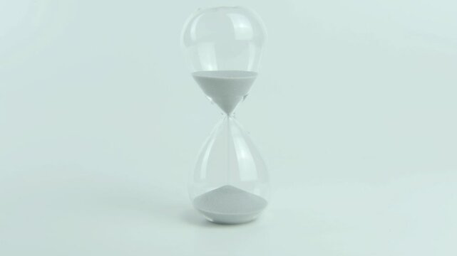 Time to focus written on a yellow sticky note placed on an hourglass. Represents concentration, productivity, and mental clarity. White background