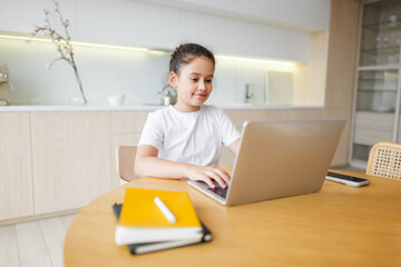 Young girl engaged in creative activities at modern kitchen table