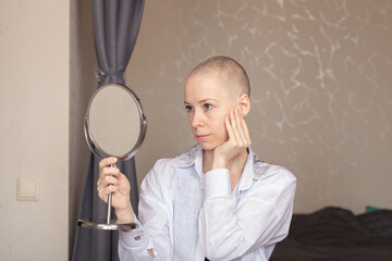 Bald Woman Looking in Mirror After Chemotherapy.Cancer Recovery, Reflection and Strength