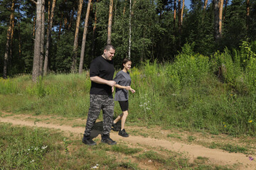 Parent and child doing a morning run in pine forest, symbolizing motivation, wellness goals