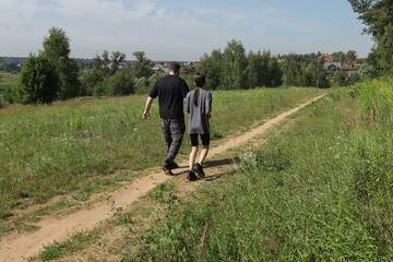 Family fitness in the countryside: dad and teen running together on forest path under the summer sun, symbolizing support, togetherness, and self-care.