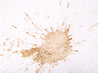 Light brown coffee splatters and streaks on a white background.