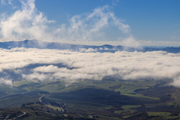 Panoramic view of a cloud sea over rolling hills in the surroundings of Volterra in Tuscany, Italy