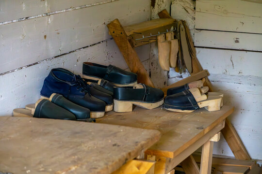 Old-fashioned shoemaker's workshop with wooden clogs and traditional shoe lasts. Rustic handmade craftsmanship tools.
