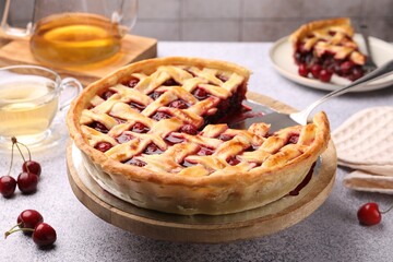 Tasty cherry pie and berries on grey textured table, closeup