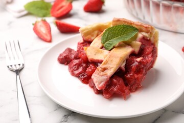 Piece of tasty strawberry pie and fork on white marble table, closeup
