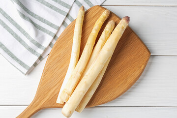 Raw asparagus spears on white wooden table, top view