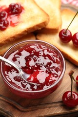 Toasts with tasty cherry jam and fresh fruits on table, closeup