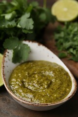 Tasty sauce with cilantro on table, closeup