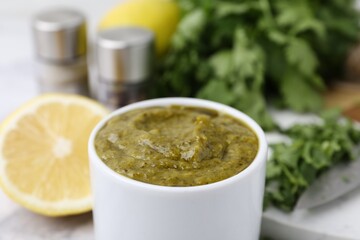 Tasty sauce with cilantro and other ingredients on table, closeup