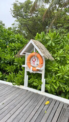 Lifebuoy ring mounted on tropical pier for beach safety — emergency equipment concept