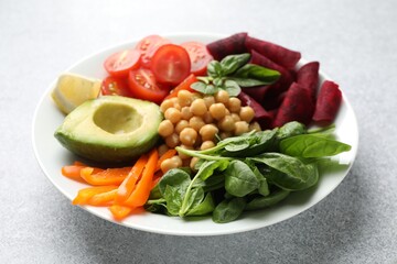 Different healthy vegetarian food on light grey table, closeup