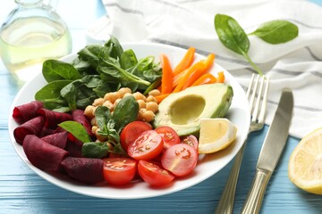 Different healthy vegetarian food and cutlery on light blue wooden table, closeup