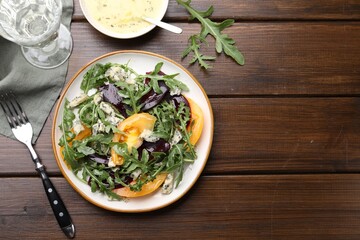 Tasty salad with arugula, blue cheese and vegetables on wooden table, flat lay. Space for text