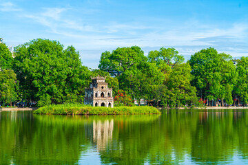 View of Turtle Tower at Hoan Kiem Lake in spring with beautiful reflection, an important historical building in Hanoi, Vietnam