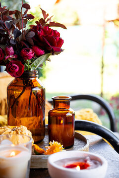 Autumn cozy mood composition on the porch. Pumpkins, autumn flowers, candles on the tray vertical photo