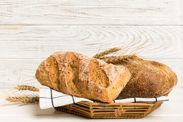 Freshly baked bread on basket against natural background. Perspective view bread copy space