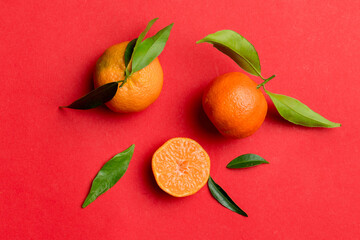 Many fresh ripe mandarin with green leaves on colored background, top view, space for text