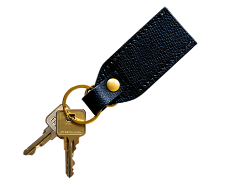 Close up of a black leather keychain with brass ring and house keys isolated on transparent background
