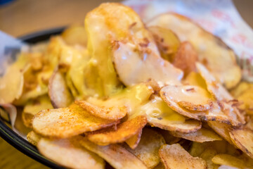 Fried crisps with cheese on top, on plate