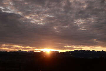 The sun is setting over the mountains, casting a warm glow over the landscape