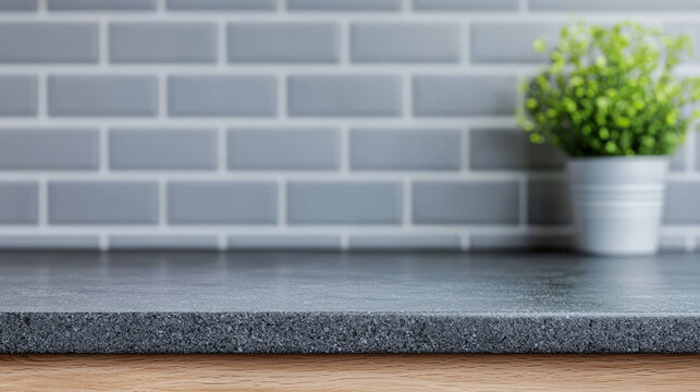 Sleek black granite countertop with gray brick backsplash and potted plant, creating modern kitchen aesthetic. combination of textures adds depth and style