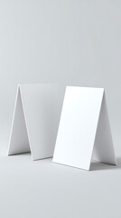 Two blank white tabletop display stands arranged on a light gray studio background clean studio shot