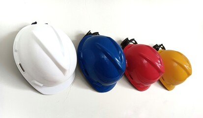 row of colorful safety helmets sits on white wall