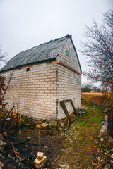 An old, abandoned brick house with a staircase, which is located in an abandoned and lonely place, sadness and melancholy