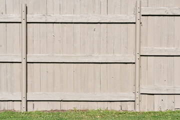 Tan colored wooden fence on ballfield.