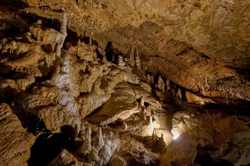 Karst formations inside Punkva Cave with illuminated stalactites and stalagmites, Moravian Karst, Czech Republic.